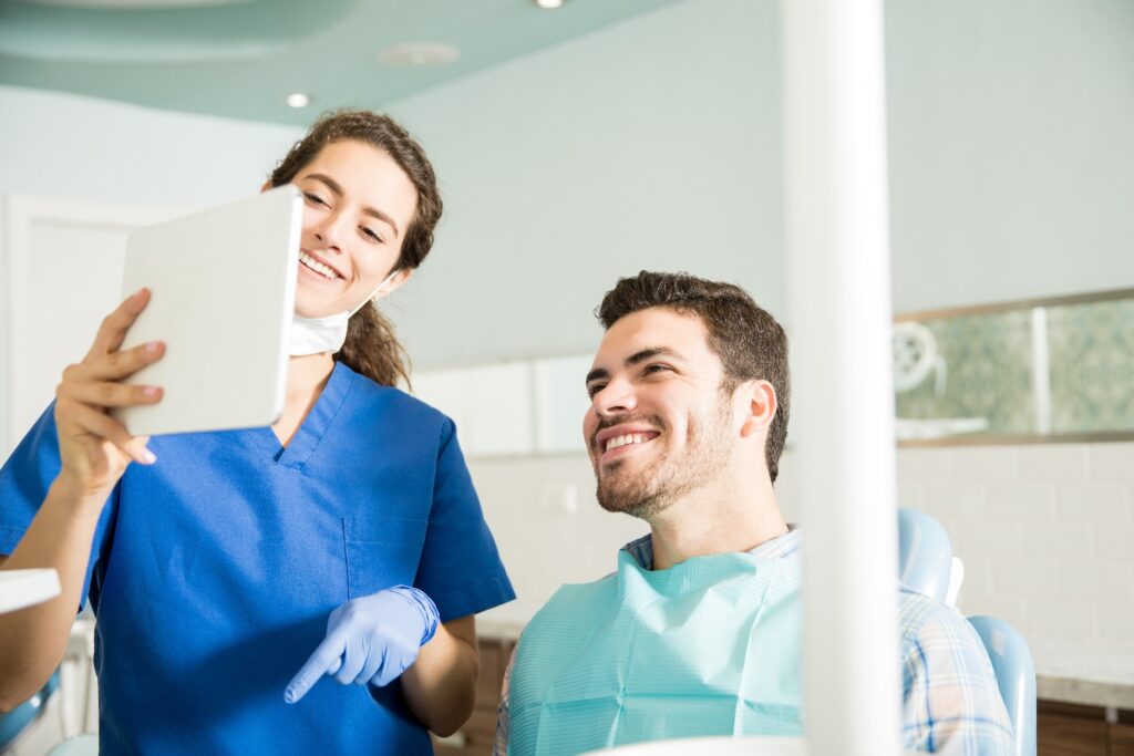 Smiling dentist explains procedure to patient